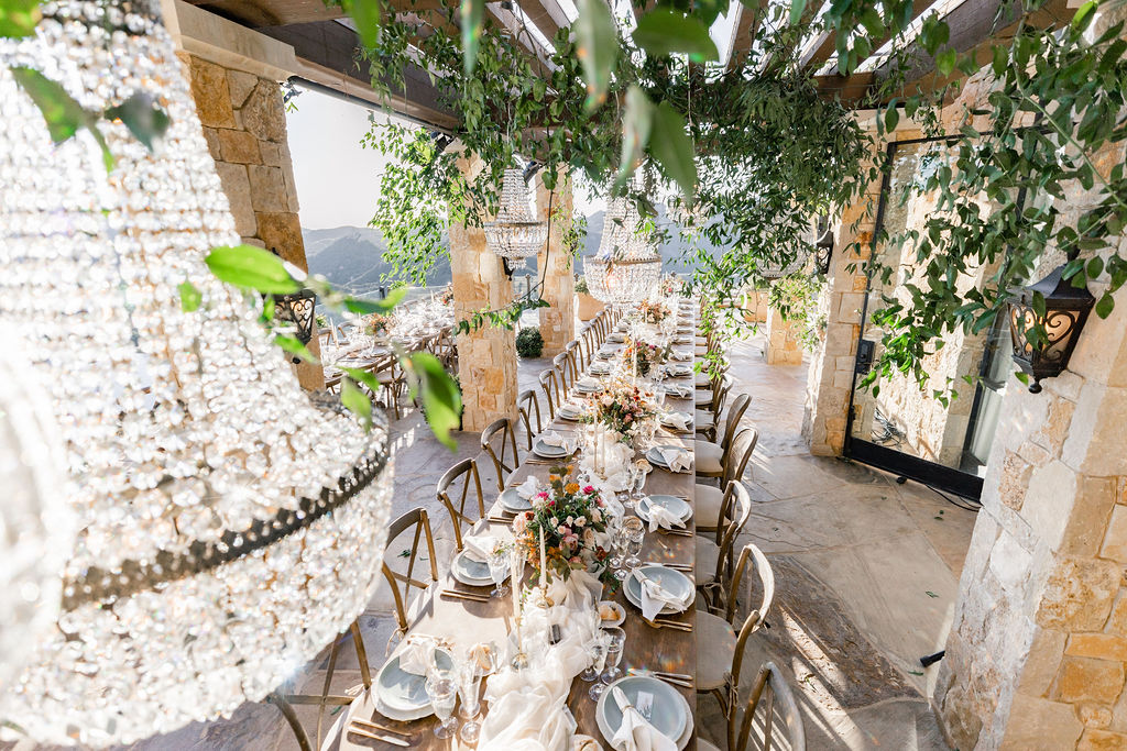 Table View Before Wedding Reception with Greenery and Chandeliers 