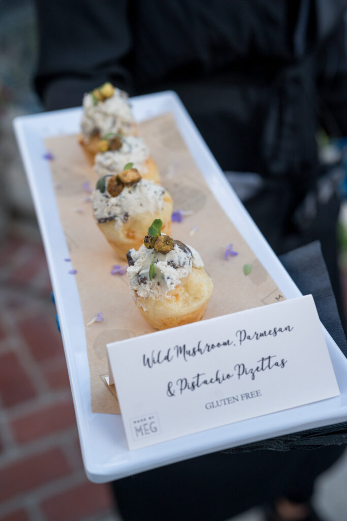 Wild Mushrooms, Parmesan & Pistachio Pizettas, Gluten Free Passed Appetizer on a white plate with brown paper 