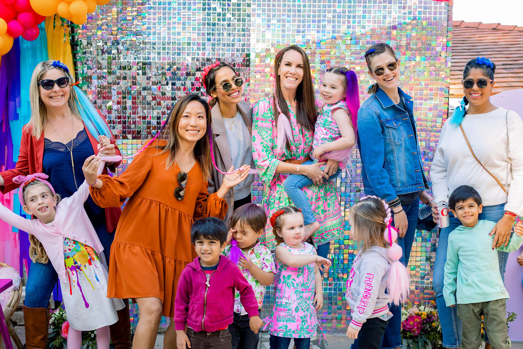 Families in front of photo booth backdrop at My Little Pony party 