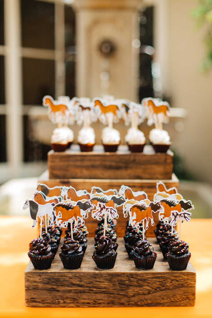 Different flavors of mini cupcakes displayed at a childrens party on wooden blocks