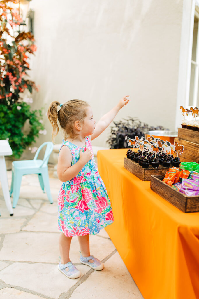 Young girl counting cupcakes to ensure there are enough for the party