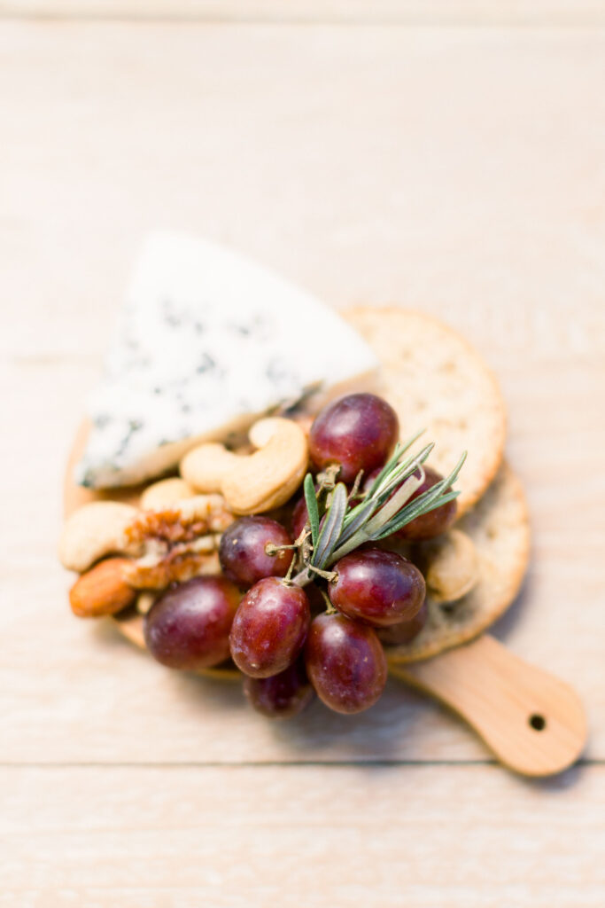 Individual Mini Cheese Board with red grapes, fresh rosemary, nuts, crackers, andcheese