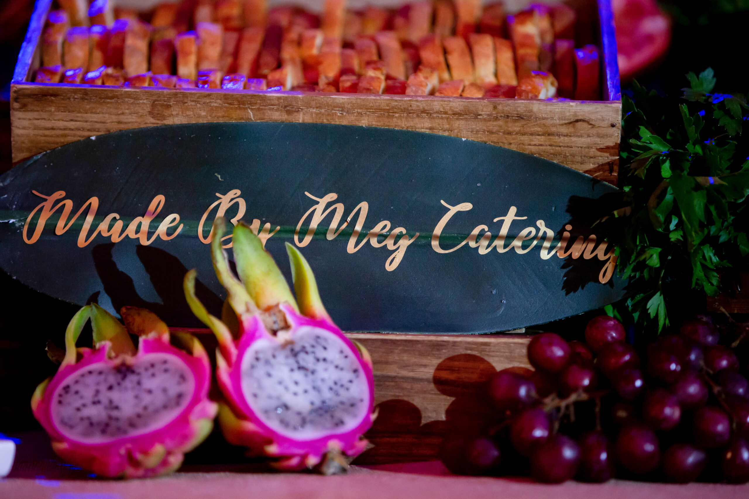 Made by Meg Catering Grazing Table with Dragon Fruit cut in half, crostini, and grapes