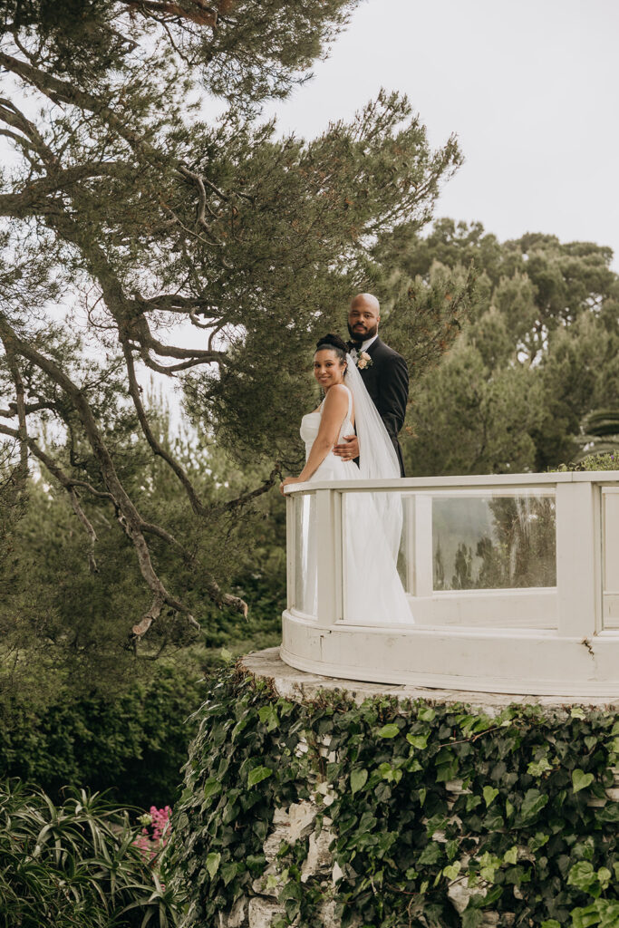 Couple Looks Over At Camera Surrounded by Greenery from Keyhole Lookout