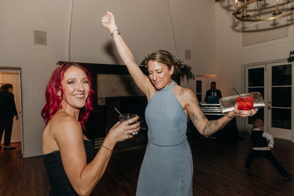 Two Girls Dancing with Cocktails at La Venta Inn Wedding Reception in front of DJ Booth