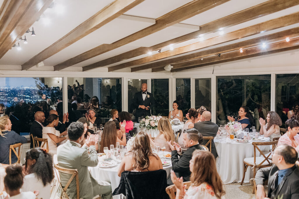 Guests Seated at Round Tables in Garden Dining Room at La Venta Inn at Night During Grooms Speech