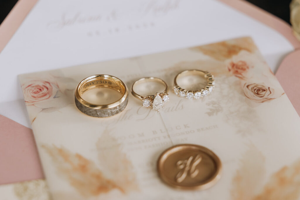 Wedding Rings and Wedding Band on top of Wedding Invite 