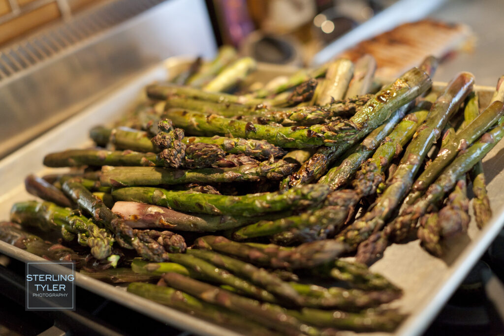Close up shot of grilled asparagus in a silver pan.