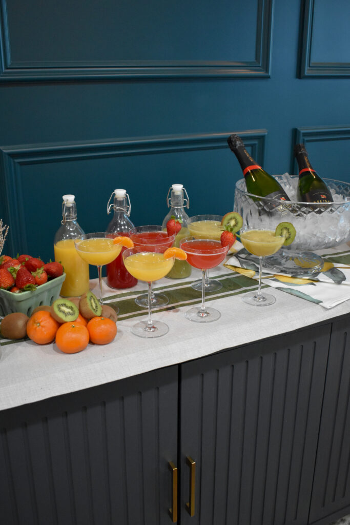 6 Camille 8-Oz. Long-Stem Champagne Coupe Glasses filled with different mimosas with different juices: freshly squeezed tangerine juice, strawberry juice, and kiwi juice